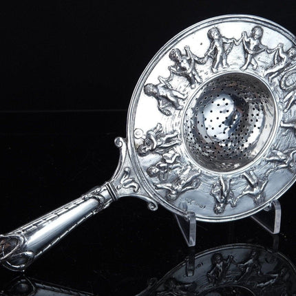 800 Silver Tea Strainer Allegorical Cherubs dancing and playing instruments