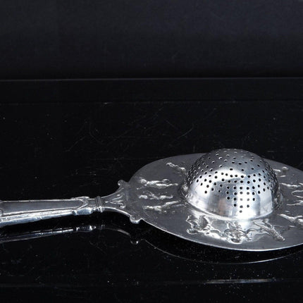 800 Silver Tea Strainer Allegorical Cherubs dancing and playing instruments