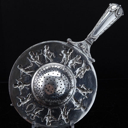 800 Silver Tea Strainer Allegorical Cherubs dancing and playing instruments